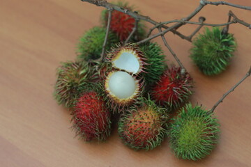 rambutan fruit which is reddish green in color having sweet taste isolated on table. Food concept photo.