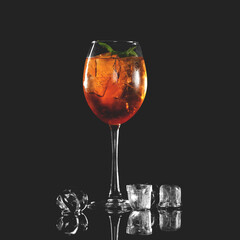 Freshly made alcoholic cocktail with brown rum, cola, ice. Glass of alcoholic drink on table with ice cubes. Dark background. reflective surface. Copy space. 