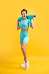 glad woman in sportswear with fitness mat in studio. fitness woman in sportswear hold mat