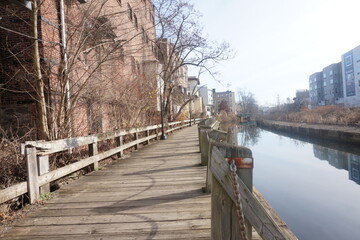 Fototapeta na wymiar Boardwalk by Canal in the City During Winter