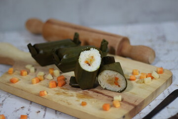 a close up of lontong. Traditional food from Indonesia originating from rice filled with vegetables or meat and wrapped in banana leaves. Indonesian traditional food photo concept.