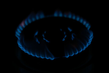 Natural gas burning a blue flames on black background.