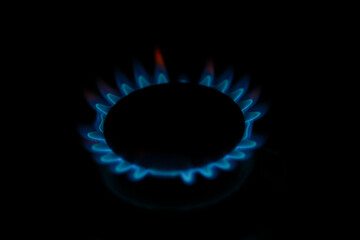 Natural gas burning a blue flames on black background.