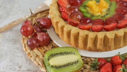 big fruit pie with toppings of strawberries, grapes, kiwi and pineapple. savory, sweet and fresh. Food concept photo.