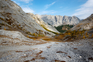 Dried up river bed in a rural countryside with the mountains in the background. Majestic landscape with the rock road and hills.