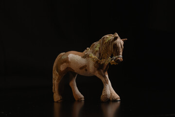 Black toy horse isolated on black background