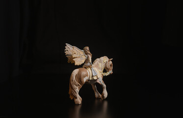 Black toy horse isolated on black background
