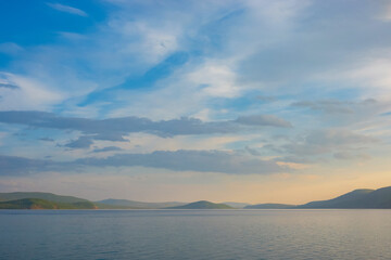 Majestic view of lake Khövsgöl, beautiful mountains in the background. Water coast with the misty looking sky with the clouds in horizon.