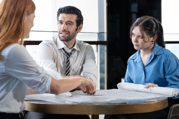 Architect meeting with client explaining construction blueprint for building renovation project. Engineer manager discussion on renovation service agreement deal with customer. Construction industry.