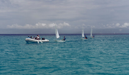 Greek Islands, Greece : 29 May 2022 : optimist sailing team on training in the sea with supervisor...