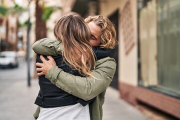 Man and woman couple smiling confident hugging each other at street