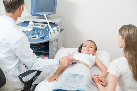 Doctor examines little patient abdomen at hospital