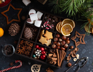 On the table there is a box with nine compartments in which nuts, cookies and spices are poured