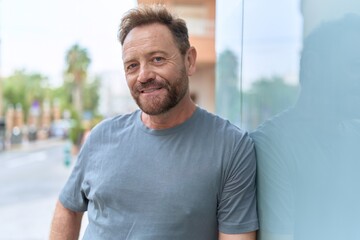 Middle age man smiling confident standing at street