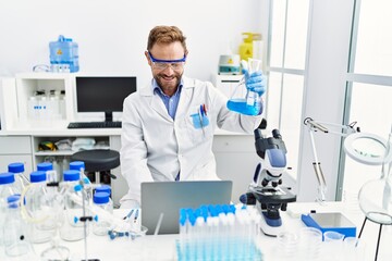 Middle age hispanic man wearing scientist uniform working at laboratory