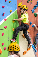 child boy practicing climbing in an indoor bouldering facility