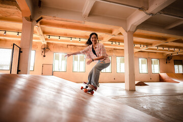 skater woman person playing skateboard in sport gym, young Asian woman are happy and fun with...