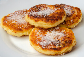 Syrniki (cottage cheese pancakes or curd fritters) in a white ceramic bowl, Healthy food. Food close-up.