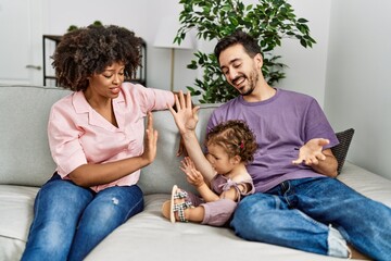 Couple and daughter smiling confident sitting on sofa at home