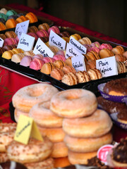 Slightly blurred macarons on a christmas market stall. Blurred donuts on foreground
