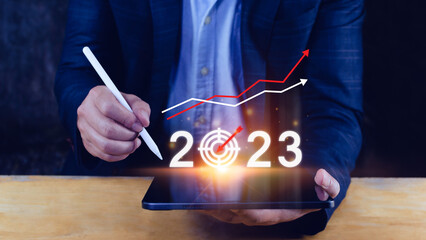 Business target and goal 2023 icon, hand pointing holding 2023 virtual screen and up arrow, Start...