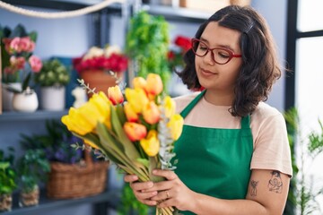 Young woman florist smiling confident prepare bouquet of flowers at florist