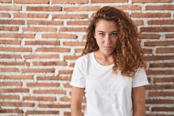 Young caucasian woman standing over bricks wall background depressed and worry for distress, crying angry and afraid. sad expression.