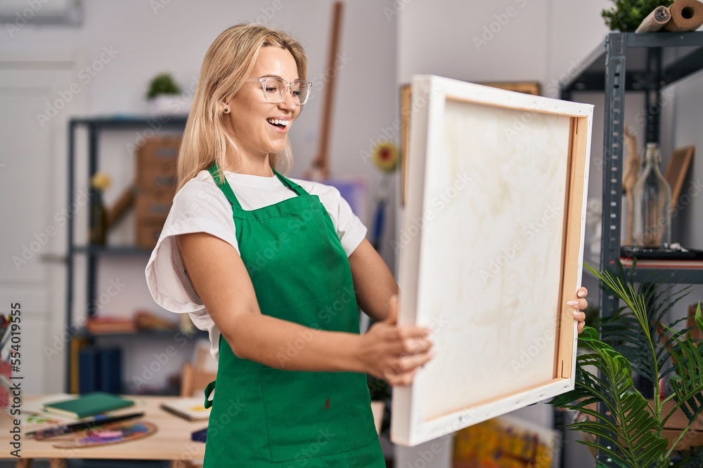 Sticker Young caucasian woman looking at canvas smiling and laughing hard out loud because funny crazy joke.