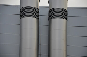 Industrial gray building with sheet metal facade of repeating rectangle paneling. on wall are two...