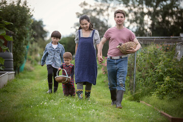 Family with baskets walking in garden grass