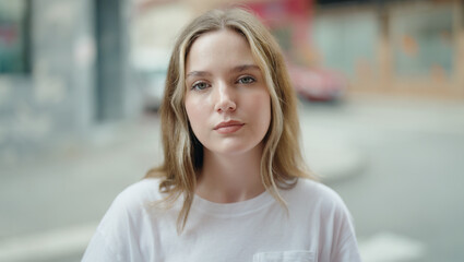 Young caucasian woman standing with serious expression at street