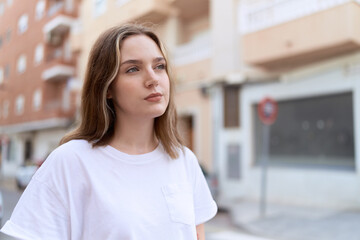 Young caucasian woman looking to the side with serious expression at street