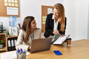 Mother and daughter business workers smiling confident working at office