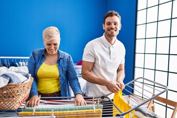 Mother and son smiling confident hanging clothes on clothesline at laundry room