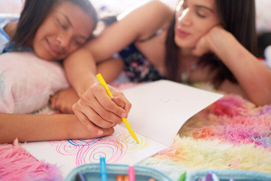 Mother And Daughter Drawing Circles In Notebook Together