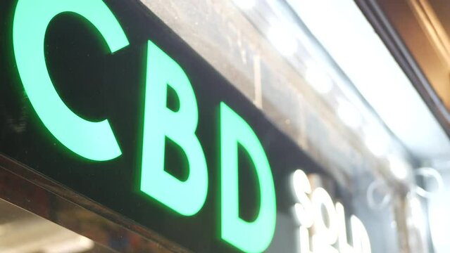 Neon sign in smoke shop, legalized cbd oil or medical cannabis in store, California USA. Legal sale of cannabidiol, weed, hemp, marijuana, ganja or hashish in dispensary. Cannabinoids in drugstore.