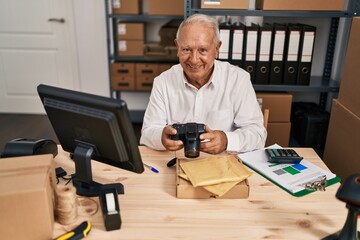 Senior man ecommerce business worker holding professional camera at office