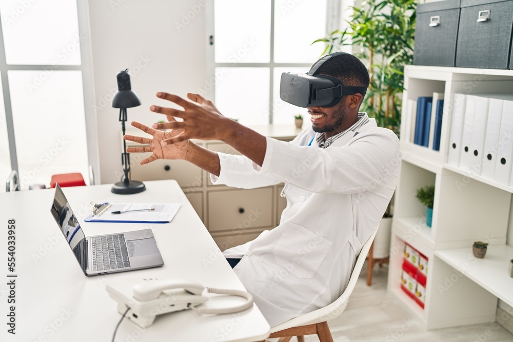 Sticker Young african american man wearing doctor uniform using virtual reality glasses at clinic