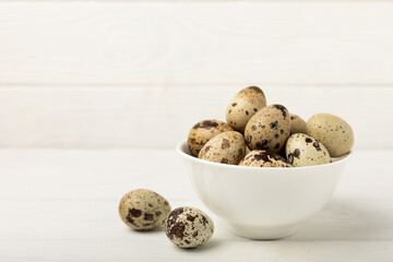 Quail eggs in a plate on a white wooden background. Healthy food. Diet. top view. free space.