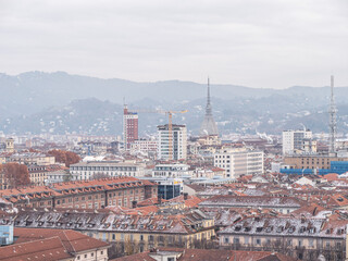 Skyline of Turin, Italy, in winter. The mountain in back and the Mole Antonelliana, Piazza Castello, Porta Susa Station, Turin court and the city centre. The city in winter with a blue sky