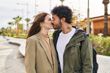 Man and woman kissing and hugging each other at street