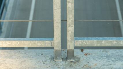 Modern metal fence made of metal profiles and cables. Connection and fastening of iron cables with a steel turnbuckles. Metal fastening of two steel rope. Fencing around the perimeter of the roof