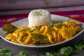 Pescado a la Macho is a Peruvian seafood dish with a cream based seafood sauce containing Peruvian spices and pieces of clams, mussels and calamari rings with rice.