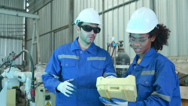Young female engineers are completing apprenticeships and learning from senior engineers. When the robotic welding equipment started up, there was a tiny jolt.