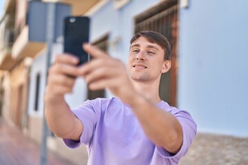 Young caucasian man smiling confident making selfie by the smartphone at street