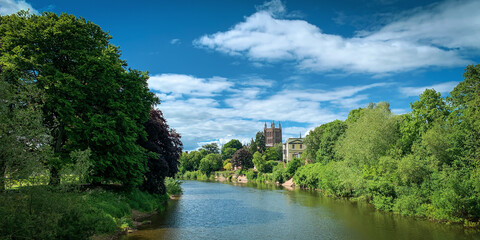 Looking across the River Wye to Hereford Cathedral on a beautiful spring day in Hereford, Herefordshire, UK. A mobile phone photo with some phone or tablet post processing. - obrazy, fototapety, plakaty