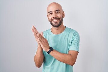 Middle age bald man standing over white background clapping and applauding happy and joyful, smiling proud hands together - obrazy, fototapety, plakaty