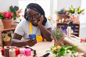 African american woman florist smiling confident using smartphone at florist - obrazy, fototapety, plakaty