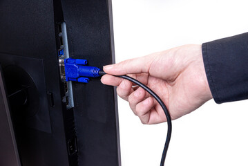 IT engineer Man hand inserts cable into monitor. Man hand connecting the DVI cable for monitor to computer PC. VGA DVI DisplayPort and power cable. close up in the hands of an . isolated