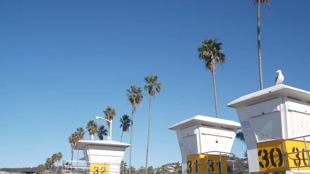 Lifeguard stand or life guard tower hut, surfing safety on California beach, USA. Summer pacific ocean aesthetic. Rescue station, coast lifesavers wachtower or house, palm trees in La Jolla, San Diego